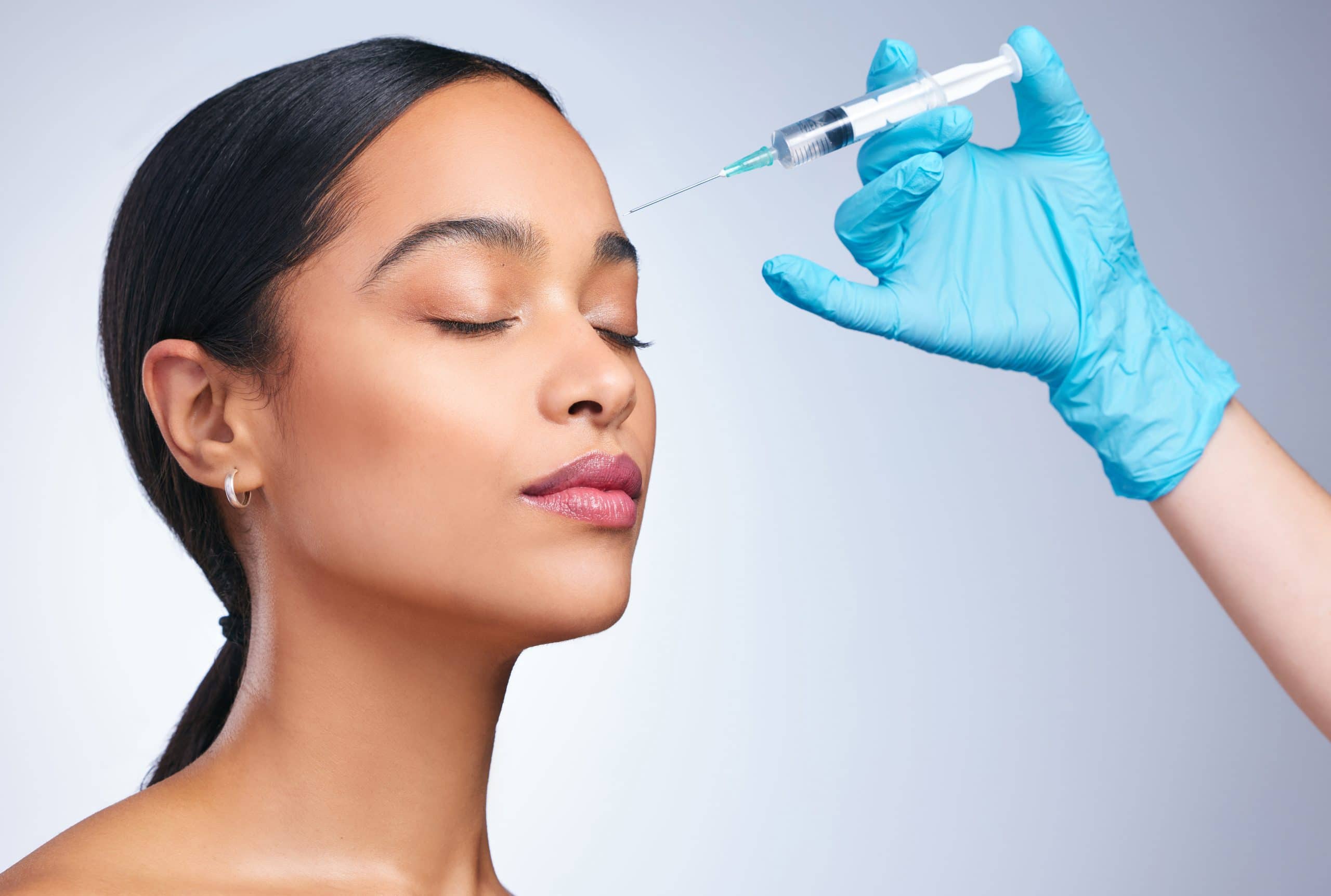 A Beautiful Woman Receives A Dermal Filler Injection Above Her Brow Line